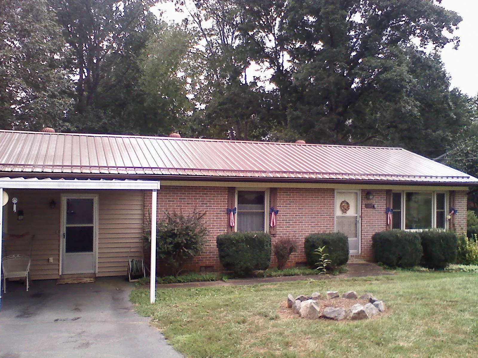 Bronze metal roof and carport on a brick ranch home — Roof Repair work by our crew in Granger
