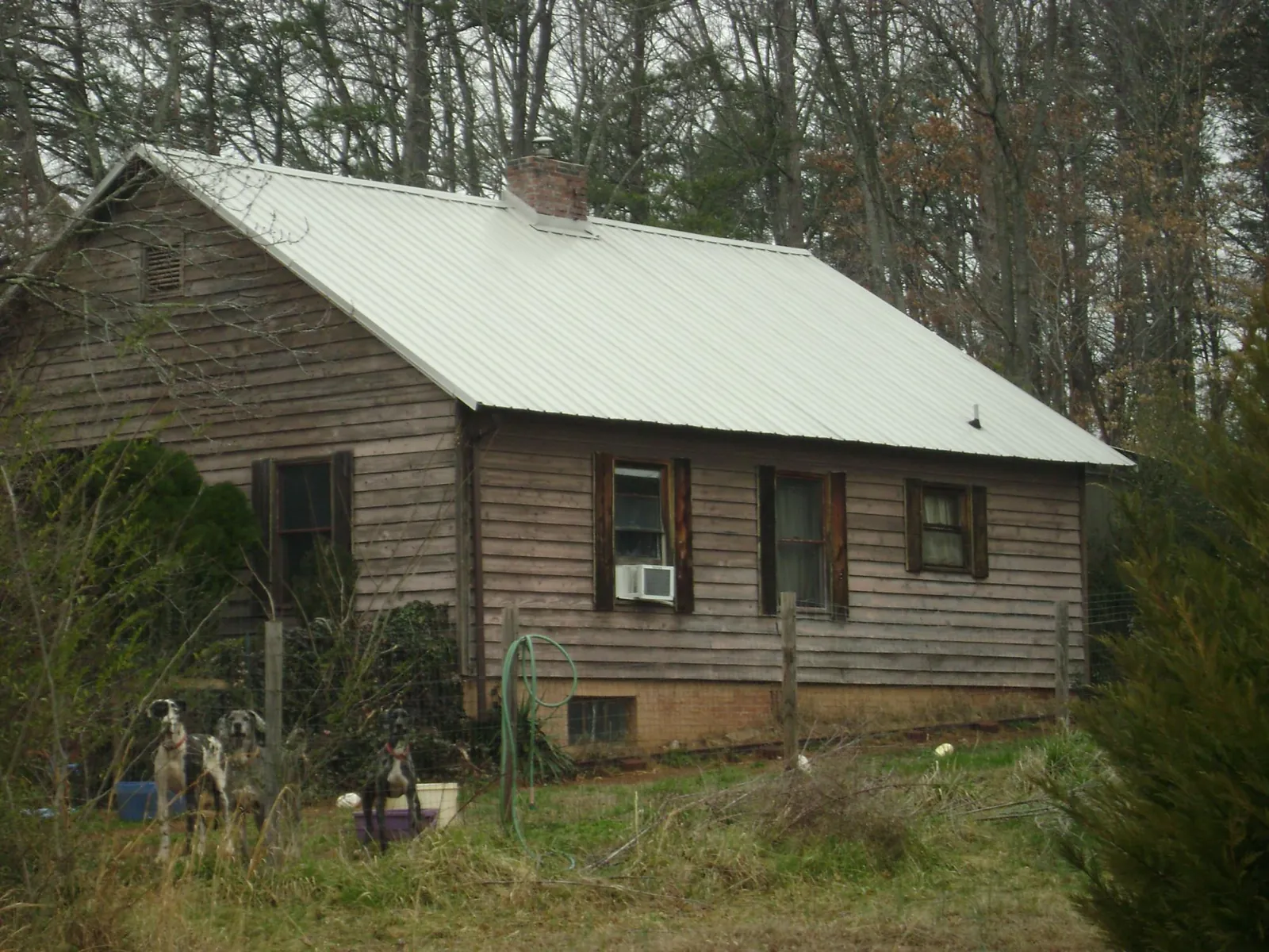 White metal roof on an old wood sided farmhouse, from a Metal Roof Installation job in Granger
